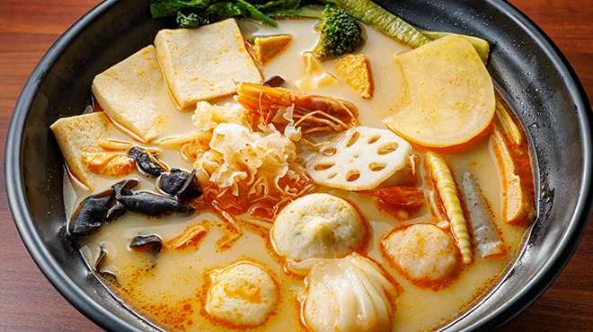 赤いスープの麻辣湯に青菜、きのこ、肉、春雨などの具材が入った器